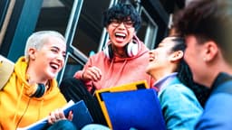 Gen Z und ihr Umgang mit Geld / Junge Menschen sitzen zusammen und lachen